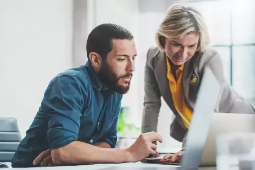 office workers looking at a laptop screen